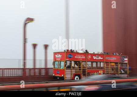 Camera panning of a moving tour bus with tourists on the Golden Gate Bridge, San Francisco, California, United States, on a foggy morning. Stock Photo