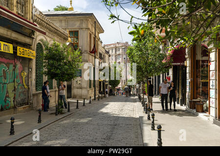 A typical street scene in the Beyoglu district of Istanbul with people walking past shops and buildings, Istanbul, Turkey Stock Photo