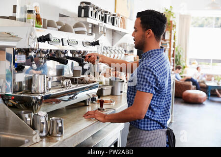 Young male barista preparing espresso at a coffee shop Stock Photo