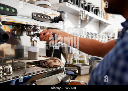 Young male barista preparing espresso at a cafe, close up Stock Photo