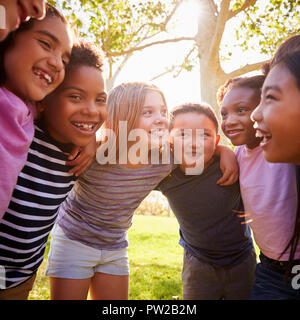 School kids embrace standing in a circle, square format Stock Photo