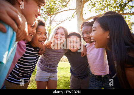 Group of schoolchildren embrace standing in a circle Stock Photo