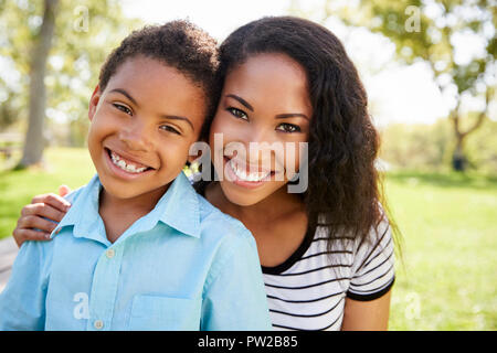 Portrait Of Smiling Mother With Son Relaxing In Park Stock Photo
