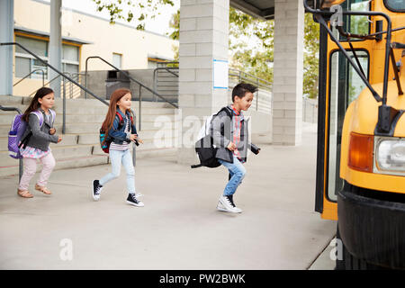 Elementary school kids leaving school to get the school bus Stock Photo
