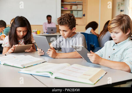 Elementary school kids using tablet computers in class Stock Photo