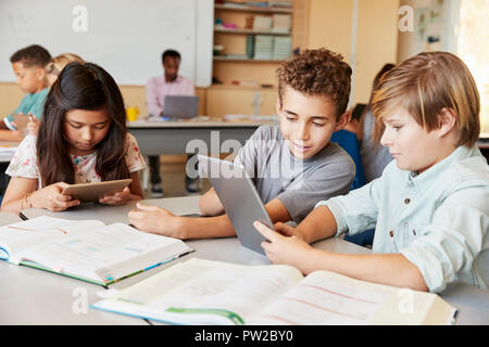 Schoolboys working together with tablet computer in class Stock Photo