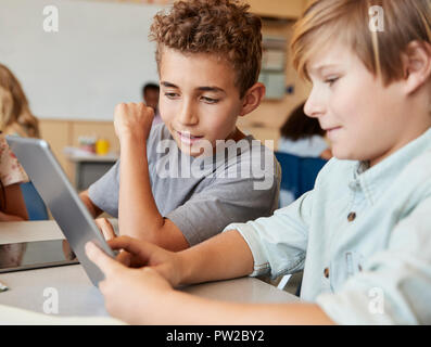 Schoolboys working together with tablet computer, close up Stock Photo