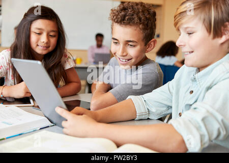Elementary school boys using tablet computer in school class Stock Photo