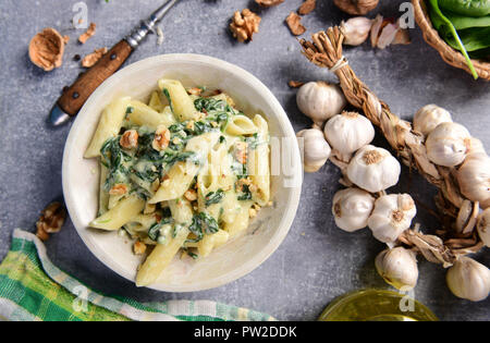 Penne pasta with spinach, gorgonzola cheese and walnuts Stock Photo