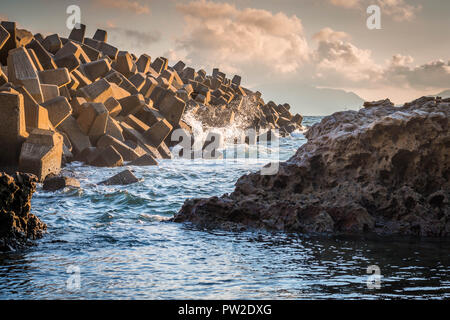 Tetrapods structures on the beach during sunset or dusk as protection for big waves in Wakamatsu, Fukuoka, Japan. Stock Photo