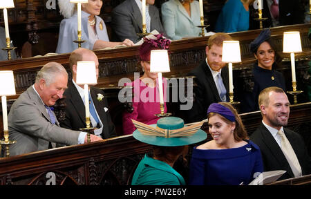 (Centre row left to right) The Prince of Wales, The Duke and Duchess of Cambridge and the Duke and Duchess of Sussex. (front row left to right) Sarah, Duchess of York, Princess Beatrice of York and Peter Phillips take their seats ahead of the wedding of Princess Eugenie to Jack Brooksbank at St George's Chapel in Windsor Castle. Stock Photo