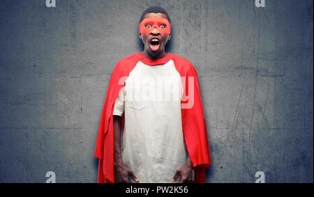 African black super hero man stressful, terrified in panic, shouting exasperated and frustrated. Unpleasant gesture. Annoying work drives me crazy Stock Photo