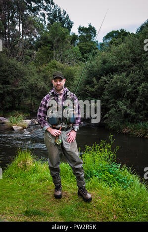 Expert fly-fishing angler, well prepared  and continuing to hone his fly-fishing skills in a wild river habitat. Stock Photo