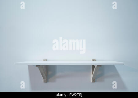 Empty wooden shelf on white wall Stock Photo