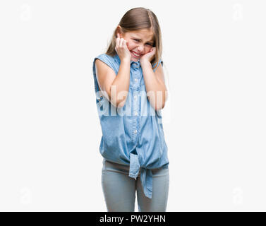 Young beautiful girl over isolated background covering ears with fingers with annoyed expression for the noise of loud music. Deaf concept. Stock Photo