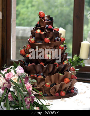 An absolutely stunning, and delicious looking, wedding cake that has many folds of chocolate and covered with strawberries. It is almost too good to eat! Stock Photo