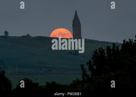 The Full Moon, known in May as the Flower Moon, rises above Hartshead Pike near Ashton-Under-Lyne Stock Photo