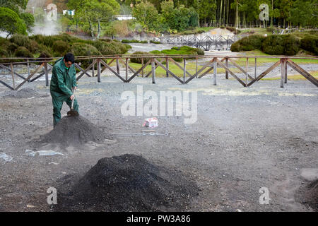 A man digging a hole in Fumarolas da Lagoa das Furnas for Cozido das Furnas on Sao Miguel Island in Azores, Portugal Stock Photo