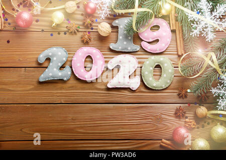 Colorful stitched digits 2019 2020 of polkadot fabric with Christmas decorations flat lyed on wooden background Stock Photo