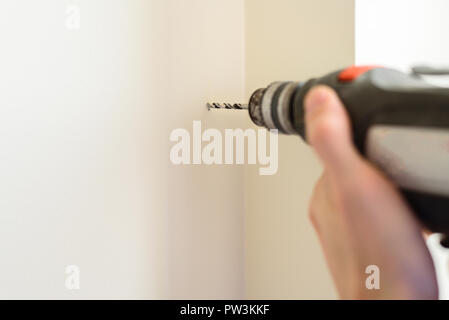 Worker drilling hole in wall with an electric drill. Copy space Stock Photo
