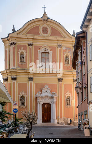 view of Santa Maria parish church facade in little town on shore of Garda lake, shot in bright fall light at Riva del Garda, Trento, Italy Stock Photo