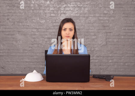 business woman sitting at a desk behind her computer Stock Photo
