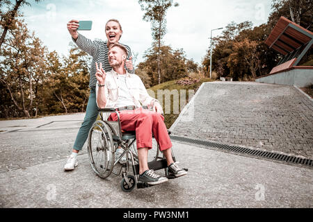 Cute couple making funny faces while taking selfies Stock Photo
