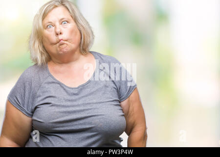 Senior plus size caucasian woman over isolated background making fish face with lips, crazy and comical gesture. Funny expression. Stock Photo