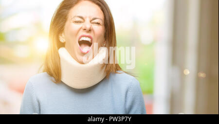 Injured woman wearing neck brace collar stressful, terrified in panic, shouting exasperated and frustrated. Unpleasant gesture. Annoying work drives m Stock Photo