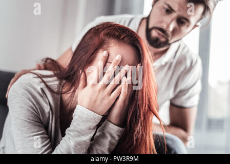 Cheerless moody woman covering her face Stock Photo