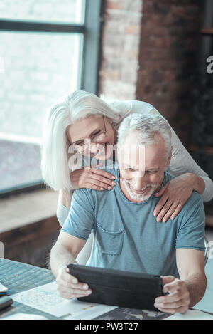 Nice happy woman standing behind her husband Stock Photo