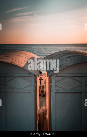 Details from lovely white beach huts in Europe. Windy sunny day, blue hazy mood, winter sunset to dusk moment. Peacefull day ending, Curved rooftops. Stock Photo