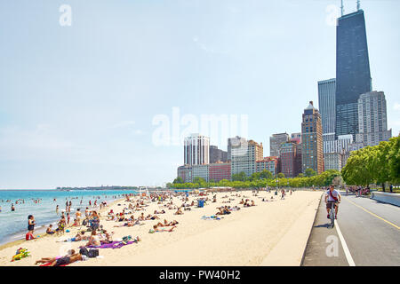 People Enjoying the water and the sun at the Oak Street Beach in Chicago, Illinois, the United States Stock Photo