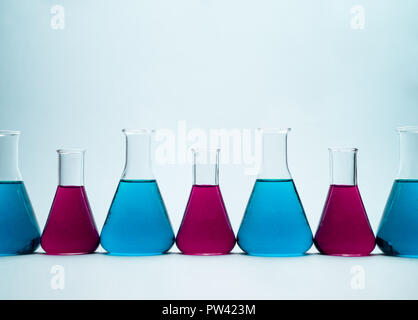 Multiple erlenmeyer flasks over light blue background Stock Photo
