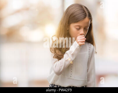 Brunette hispanic girl feeling unwell and coughing as symptom for cold or bronchitis. Healthcare concept. Stock Photo