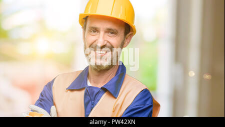 Senior engineer man, construction worker with crossed arms confident and happy with a big natural smile laughing Stock Photo