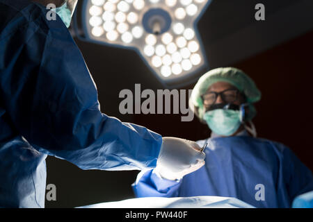 Asian doctor and an assistant in the operating room for surgical venous vascular surgery clinic in hospital. Stock Photo