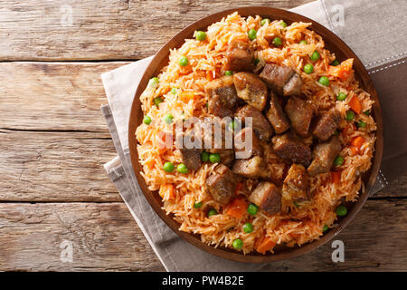 Mexican traditional food: rice cooked with tomatoes, green peas and carrots served fried pork closeup on the table. horizontal top view from above Stock Photo