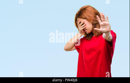 Young beautiful woman over isolated background covering eyes with hands and doing stop gesture with sad and fear expression. Embarrassed and negative  Stock Photo