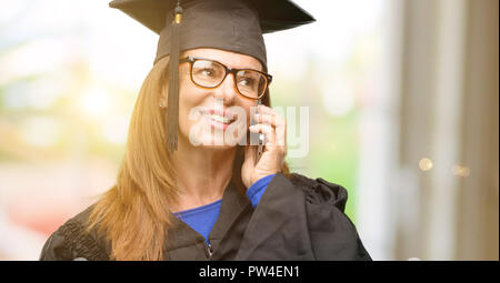 Senior graduate student woman happy talking using a smartphone mobile phone Stock Photo