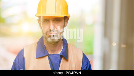 Senior engineer man, construction worker with sleepy expression, being overworked and tired Stock Photo