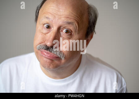 Portrait of happy and cheerful senior mature man smiling and excited gesturing funny and comic in laughter in Facial Expressions Human Emotions concep Stock Photo
