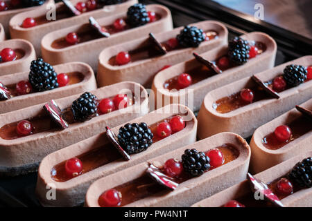 sweet cream tart cake pieces with blackberries and currants on dessert buffet  - Stock Photo