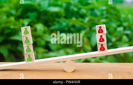 Cubes on scales with green patterns of money outweigh the red. The concept of surplus, profit growth and business profitability. Optimistic outlook, s Stock Photo