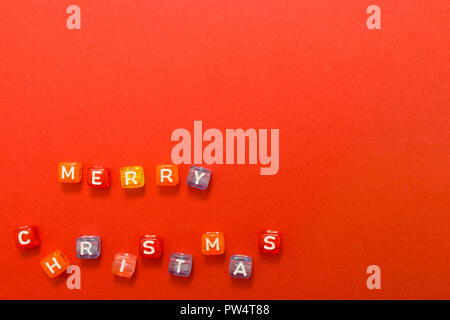 words merry christmas made of colorful blocks on red background. Flat lay, top view - holidays, winter, christmas and new year celebration concept. co Stock Photo