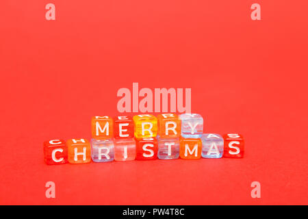 words merry christmas made of colorful blocks on red background. Flat lay, top view - holidays, winter, christmas and new year celebration concept. co Stock Photo