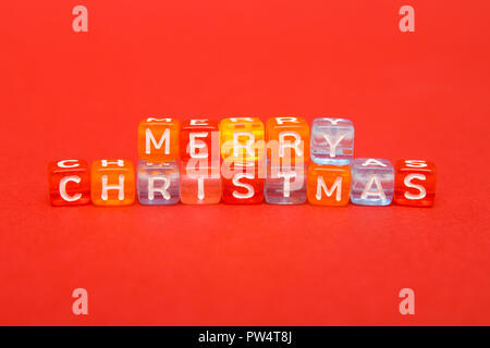 words merry christmas made of colorful blocks on red background. Flat lay, top view - holidays, winter, christmas and new year celebration concept Stock Photo