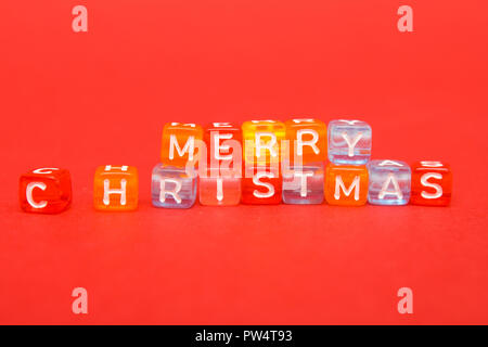 words merry christmas made of colorful blocks on red background. Flat lay, top view - holidays, winter, christmas and new year celebration concept Stock Photo