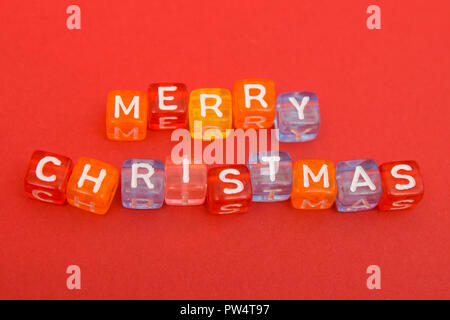 words merry christmas made of colorful blocks on red background. Flat lay, top view - holidays, winter, christmas and new year celebration concept Stock Photo