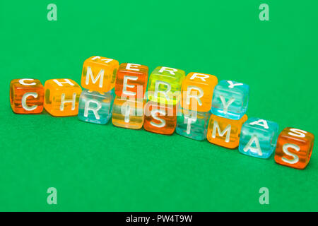 words merry christmas made of colorful blocks on green background. Flat lay, top view - holidays, winter, christmas and new year celebration concept Stock Photo